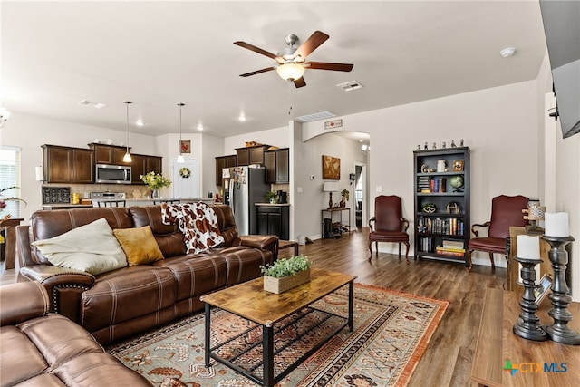 living room featuring dark wood-type flooring and ceiling fan