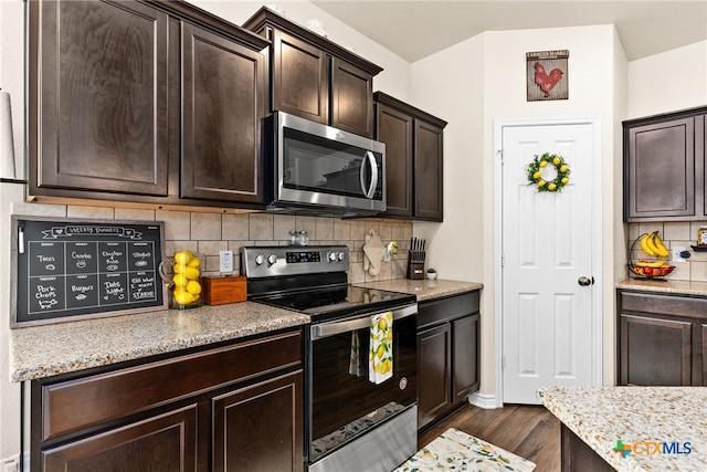 kitchen with tasteful backsplash, dark brown cabinets, dark hardwood / wood-style floors, and stainless steel appliances