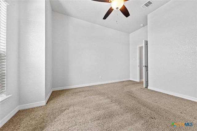 carpeted spare room featuring ceiling fan and lofted ceiling