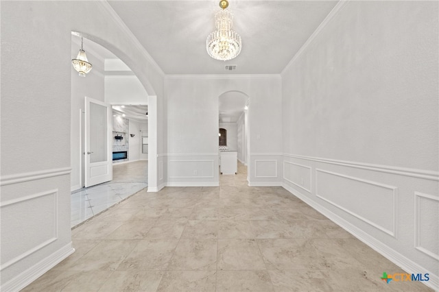 spare room with a notable chandelier and ornamental molding