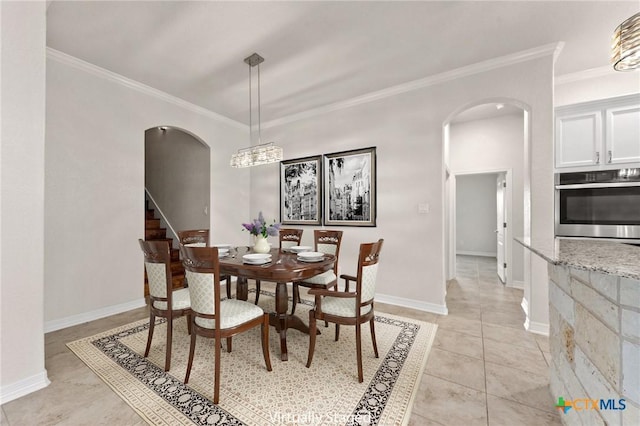 tiled dining space featuring an inviting chandelier and ornamental molding