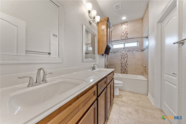 full bathroom with tile patterned flooring, tiled shower / bath combo, toilet, and vanity