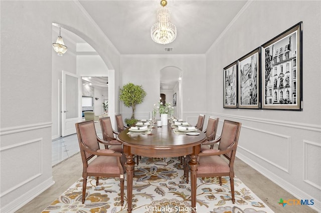 tiled dining room featuring crown molding and a chandelier