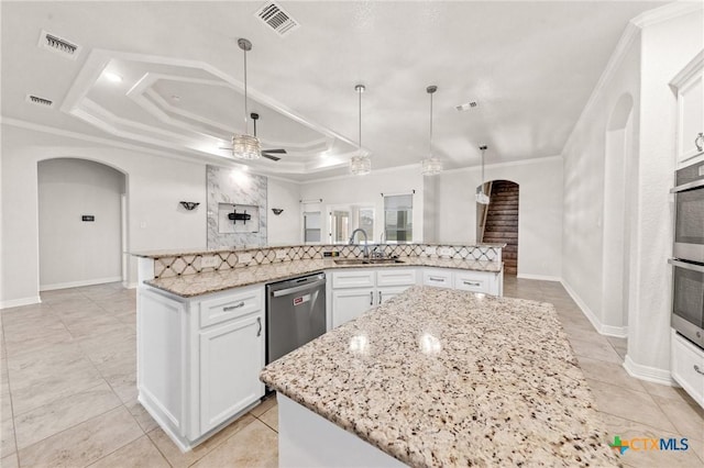 kitchen featuring a tray ceiling, white cabinetry, ceiling fan, and a large island