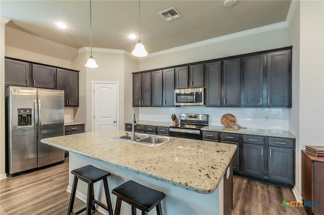 7106 Boulder Star Way, Temple, TX 76502 - kitchen with stainless steel appliances, a sink, ornamental molding, dark wood finished floors, and light stone countertops