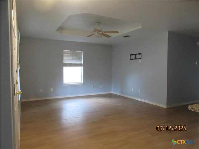 1109 E E Avenue M, Belton, TX 76513 - spare room featuring a ceiling fan, wood finished floors, and a tray ceiling