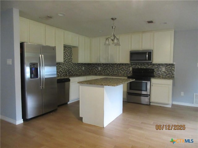 1109 E E Avenue M, Belton, TX 76513 - kitchen featuring appliances with stainless steel finishes, decorative backsplash, light wood-type flooring, white cabinetry, and a kitchen island