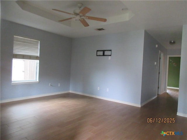 1109 E E Avenue M, Belton, TX 76513 - empty room with wood finished floors, ceiling fan, and a tray ceiling