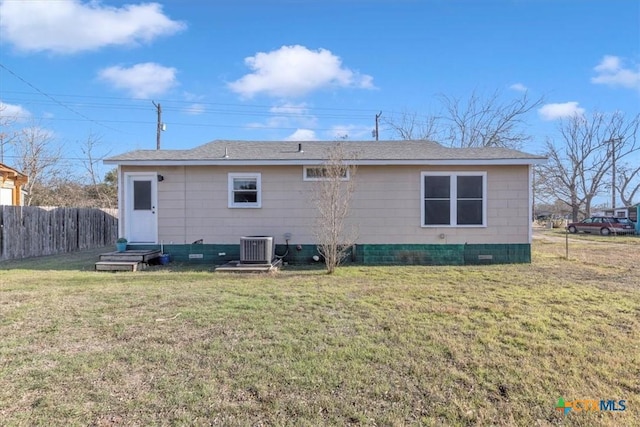 back of house featuring central AC unit and a yard