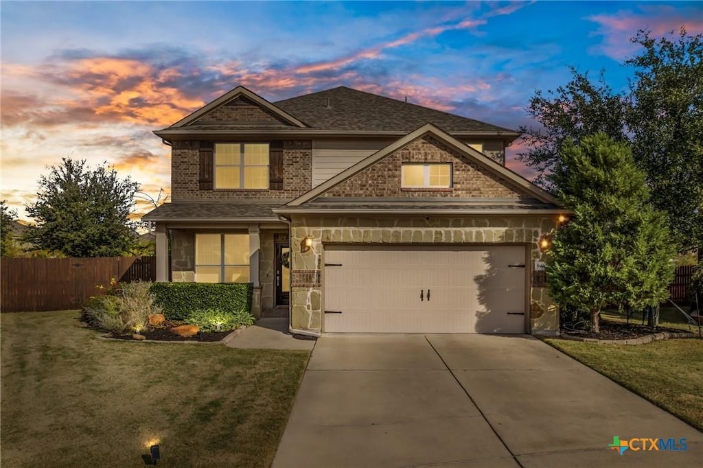 craftsman-style home featuring a lawn and a garage