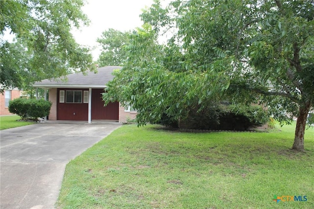 1610 Bexar Ave, Victoria, TX 77901 - view of front of property featuring concrete driveway, a front yard, an attached carport, and brick siding