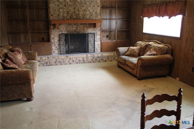 1610 Bexar Ave, Victoria, TX 77901 - living room featuring carpet floors, built in features, wooden walls, and a fireplace