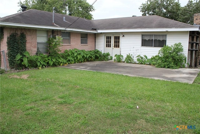 1610 Bexar Ave, Victoria, TX 77901 - view of front facade featuring a front lawn, french doors, a chimney, brick siding, and a patio area