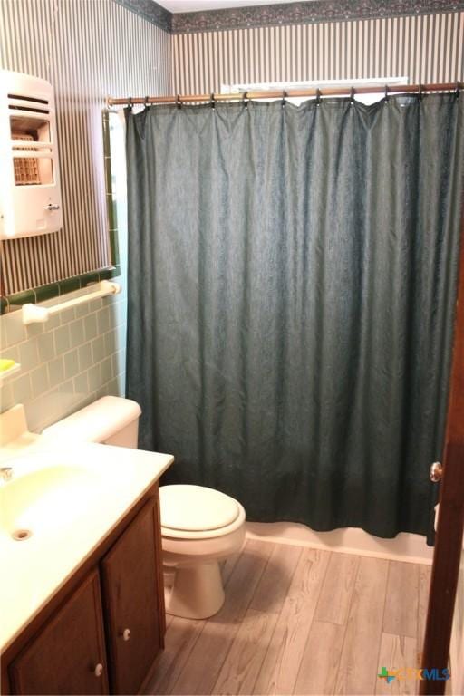 1610 Bexar Ave, Victoria, TX 77901 - bathroom featuring hardwood / wood-style floors, tile walls, wallpapered walls, vanity, and a shower with curtain
