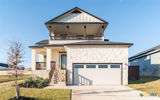 view of front of house with covered porch, a garage, a balcony, and a front yard