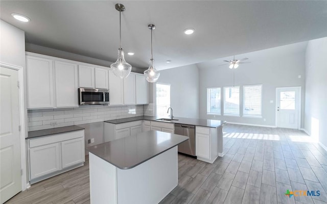 kitchen featuring a center island, sink, white cabinetry, and stainless steel appliances