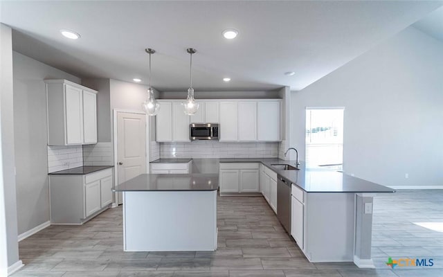 kitchen featuring white cabinets, decorative light fixtures, sink, and appliances with stainless steel finishes