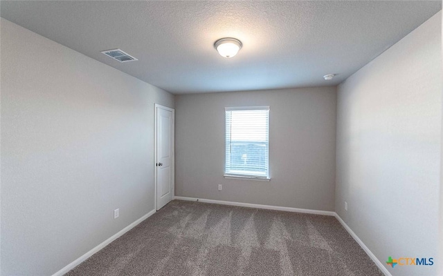 carpeted empty room featuring a textured ceiling