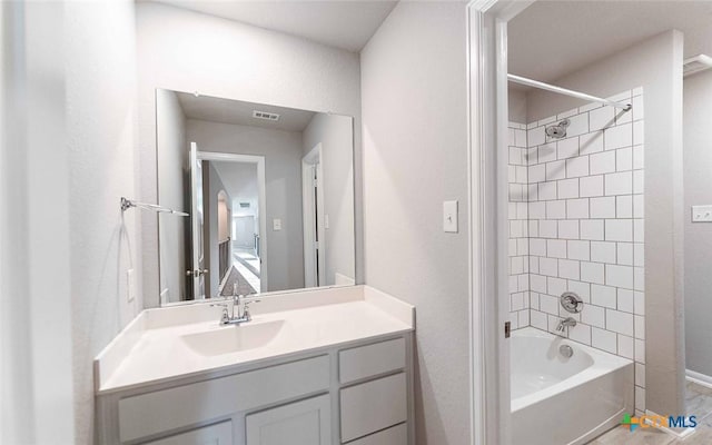 bathroom featuring vanity and tiled shower / bath