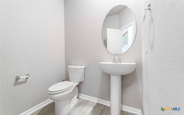 bathroom featuring hardwood / wood-style floors and toilet