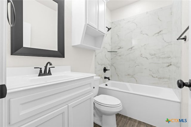 full bathroom featuring tiled shower / bath, wood-type flooring, vanity, and toilet