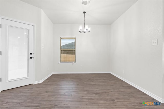 unfurnished dining area featuring a notable chandelier and dark wood-type flooring