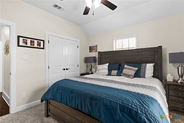 carpeted bedroom featuring a closet, vaulted ceiling, and ceiling fan