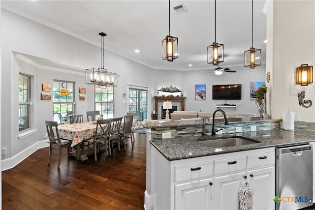 kitchen featuring dark wood-type flooring, dark stone counters, white cabinets, sink, and stainless steel dishwasher