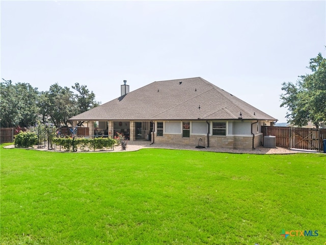 rear view of house featuring central AC unit, a patio area, and a lawn