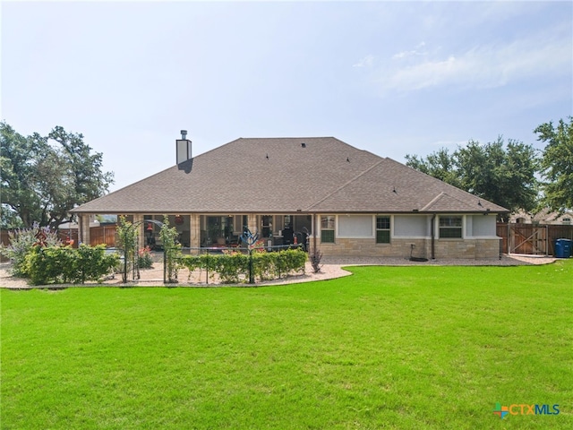 back of property with a lawn and a patio area