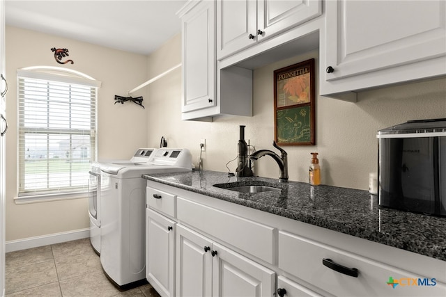 laundry room featuring cabinets, light tile patterned flooring, sink, and washer and clothes dryer