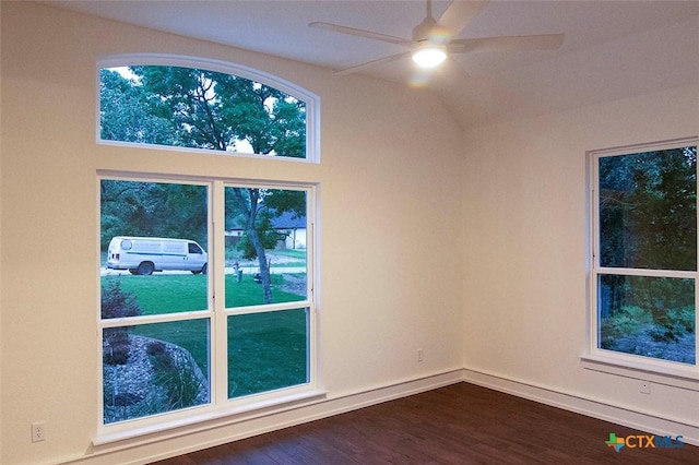 empty room featuring ceiling fan, dark hardwood / wood-style floors, and vaulted ceiling