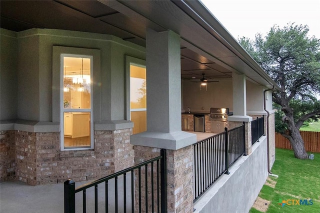 exterior space featuring an outdoor kitchen, sink, and ceiling fan