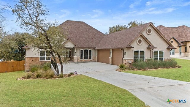 7026 Troyan Ln, Temple, TX 76502 - view of front of property featuring an attached garage, stucco siding, driveway, stone siding, and roof with shingles