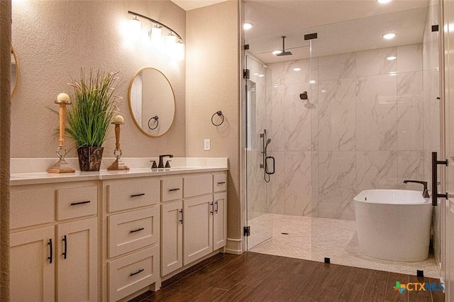 bathroom with vanity and shower with separate bathtub