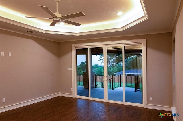 interior space featuring hardwood / wood-style flooring, ceiling fan, and a raised ceiling