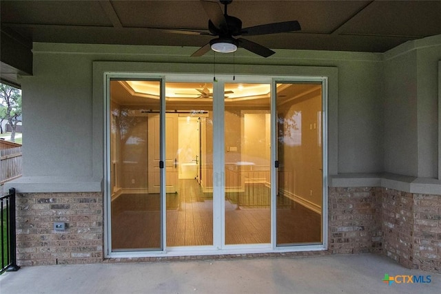 doorway to property featuring ceiling fan