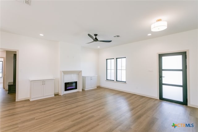 unfurnished living room with ceiling fan and light hardwood / wood-style flooring