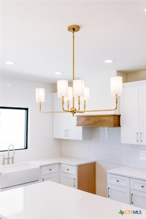 kitchen with white cabinetry, sink, and hanging light fixtures