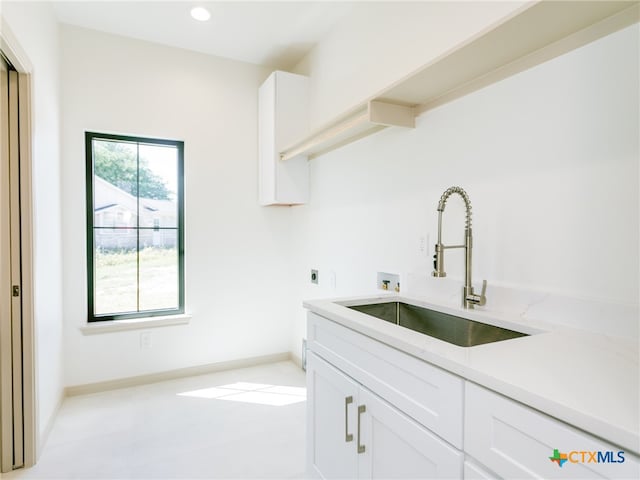 clothes washing area with cabinets, hookup for an electric dryer, sink, and washer hookup