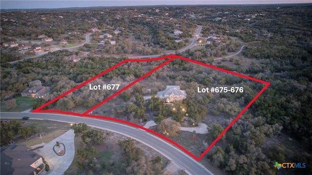 birds eye view of property featuring a forest view