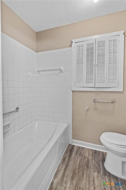 bathroom with a shower, baseboards, a tub, toilet, and wood finished floors