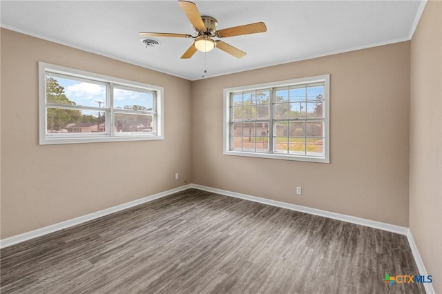 unfurnished room featuring baseboards, wood finished floors, and plenty of natural light
