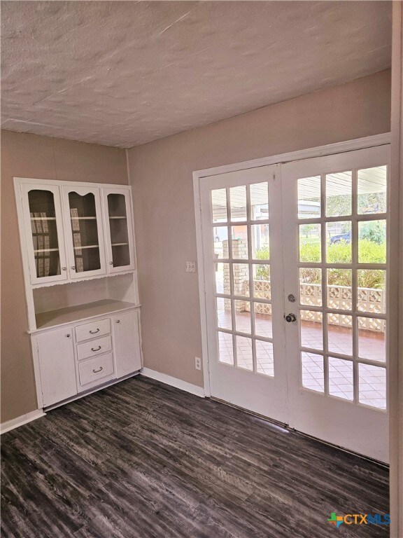 doorway to outside with french doors, dark hardwood / wood-style flooring, and a textured ceiling