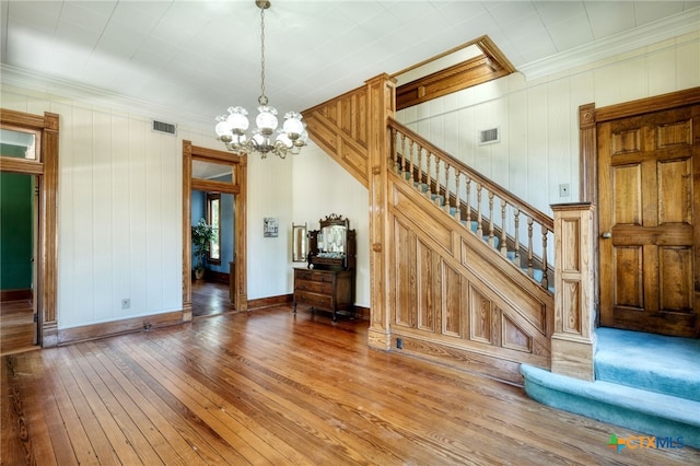 interior space featuring a chandelier, hardwood / wood-style floors, and crown molding