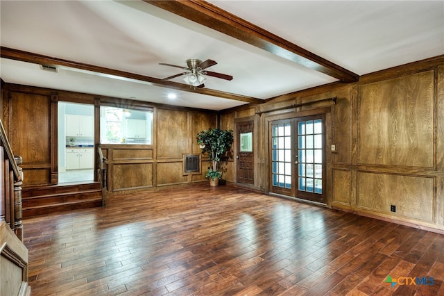 unfurnished living room featuring wood walls, ceiling fan, beam ceiling, dark hardwood / wood-style flooring, and french doors