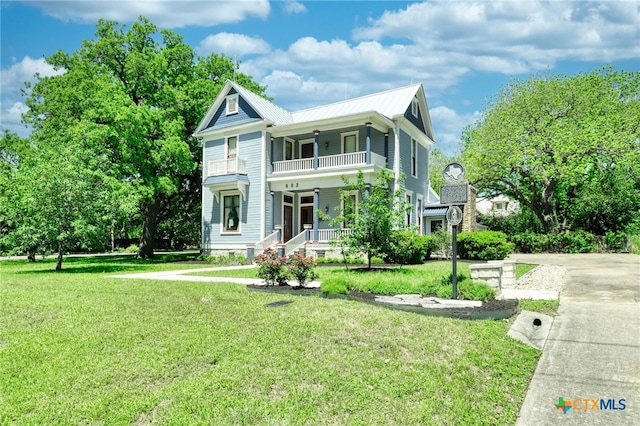 view of front of property with a porch, a front lawn, and a balcony