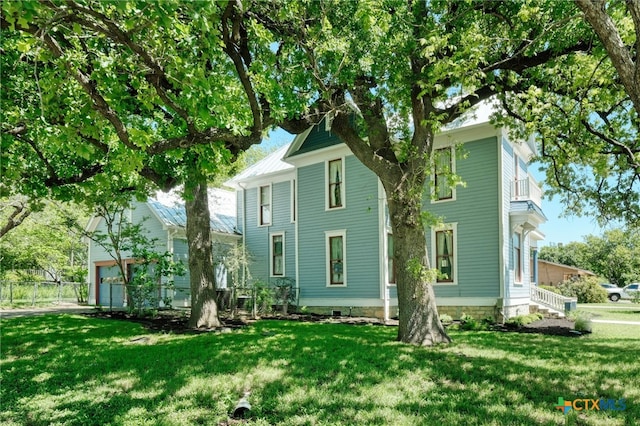 rear view of property featuring a lawn and a balcony