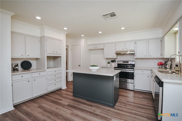 505 Bramble Bush Ln, Victoria, TX 77904 - kitchen featuring stainless steel appliances, under cabinet range hood, crown molding, dark wood finished floors, and backsplash
