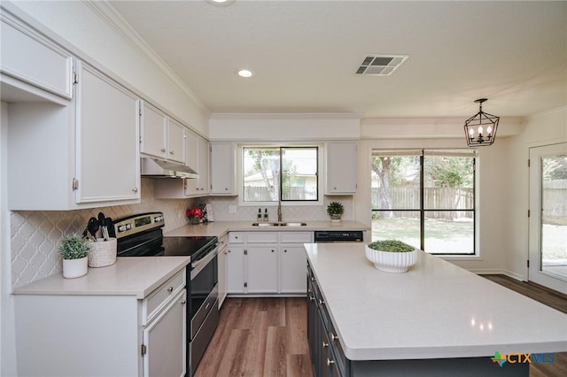 505 Bramble Bush Ln, Victoria, TX 77904 - kitchen featuring stainless steel range with electric stovetop, under cabinet range hood, light countertops, dark wood-style flooring, and ornamental molding
